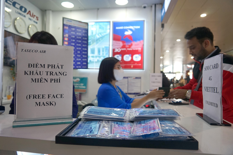 Một số đơn vị phát khẩu trang miễn phí ở sân bay. Ảnh: Gia Chính.